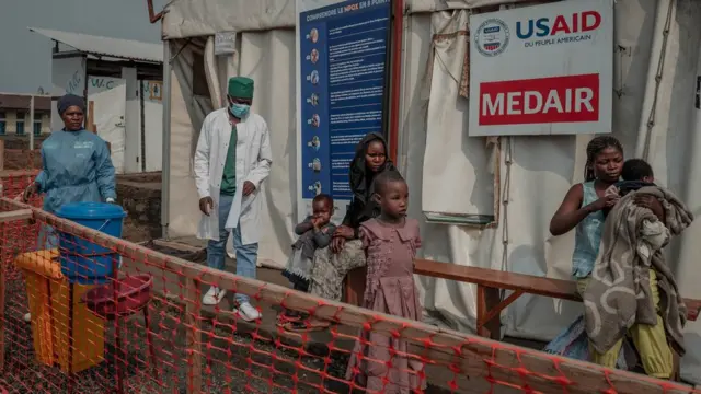 TOPSHOT - Patients wait outside the consultation room of the Mpox treatment centre at the Nyiragongo general reference hospital, north of the town of Goma in the Democratic Republic of Congo, on August 16, 2024. Health Minister Samuel-Roger Kamba said in a video message that the country "has recorded 15,664 potential cases and 548 deaths since the beginning of the year", with all 26 provinces affected. The United Nations (UN) health agency was concerned by the rise in cases and fatalities in the Democratic Republic of Congo, and the spread to Burundi, Kenya, Rwanda and Uganda. (Photo by GUERCHOM NDEBO / AFP) (Photo by GUERCHOM NDEBO/AFP via Getty Images)